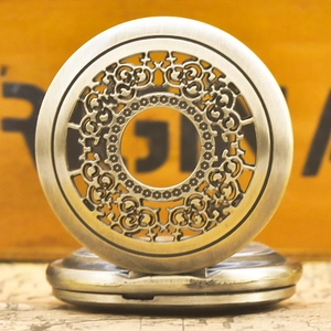 Macro detail of bronze vintage quartz pocket watch with hollow floral carving pattern