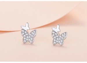 Macro shot of silver butterfly earrings featuring zircon stones and polished metallic finish