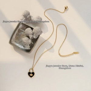 Detail of 18K gold heart necklace with black agate, bee motif and K18 hallmark