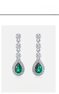 Detail of pear-cut emerald earrings in S925 sterling silver with halo cubic zirconia