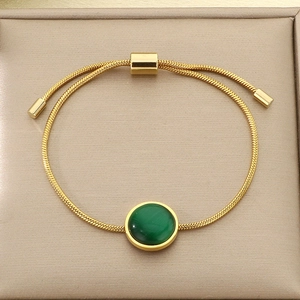 Détail d'un bracelet maille serpent dorée avec pierre malachite verte et fermoir réglable