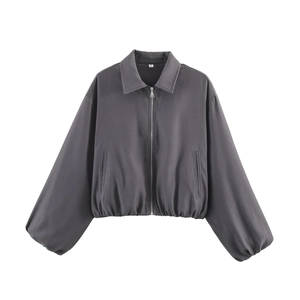 Detail of the dark gray bomber jacket zipper and woven fabric texture close-up