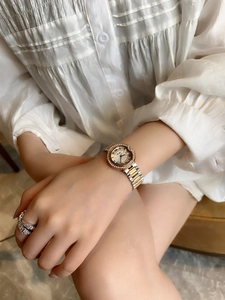 Close-up of a women watch with rhinestone bezel and two-tone metal strap on wrist