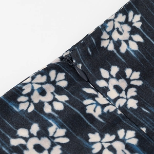 Gros plan sur la fermeture éclair invisible du jupe-short à imprimé floral bleu et blanc