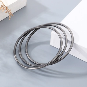 Macro detail of three 3mm minimalist matte black titanium steel stacking bangles set
