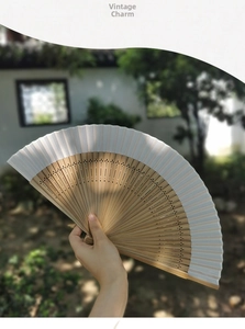 Detailed view of hand-carved bamboo ribs and minimalist fabric on a Chinese folding fan