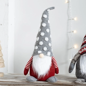 Christmas Rudolph gnome plush doll with red grey pointed hat on a wooden table