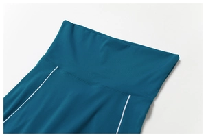 Détail du legging de yoga sarcelle à taille haute avec passepoil blanc et coutures