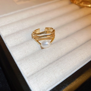 Close-up of gold-plated dragon ring featuring a lustrous white oval pearl inlay