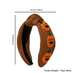 Detailed view of brown knotted fabric headband featuring beaded Halloween pumpkins