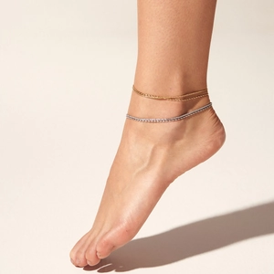 Double-layered gold chain and silver rhinestone anklet set on a model with neutral background