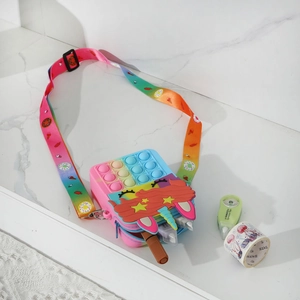 Detail of unicorn silicone pop-it bag with adjustable rainbow strap on marble surface