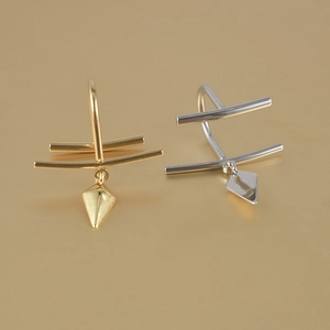 Detailed view of gold and silver U-shaped non-piercing lip rings with geometric charms