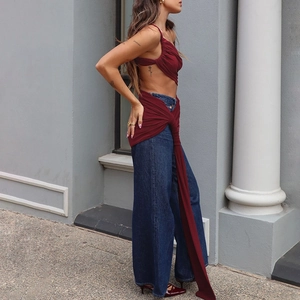 Détail du haut à lacets bordeaux avec rubans et jean bleu foncé à taille haute