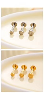 Close-up of hammered titanium flat disc labret studs in silver and gold finishes