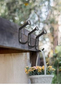 Industrial cast iron nail head hooks on dark wood beam with hanging white basket