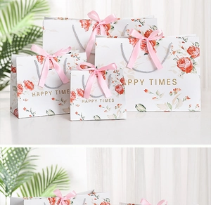 Detail of marble pattern gift bags with pink ribbon handles and rose floral design