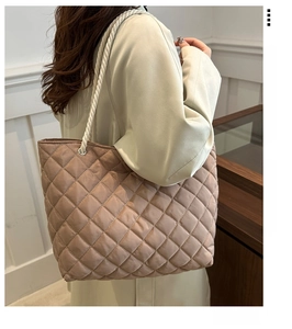 Détail d'un sac cabas en nylon matelassé avec anses en corde et œillets métalliques