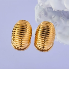 Detailed close-up of gold-plated titanium earrings with elegant striped texture design