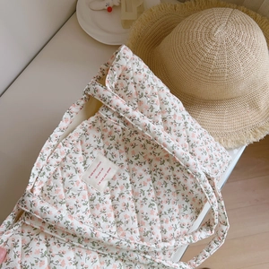 Close-up of pink floral quilted cotton tote bag featuring an elegant fabric label detail