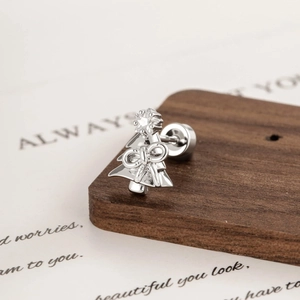 Silver Christmas tree cartilage earring with bow detail and star zircon on wood background