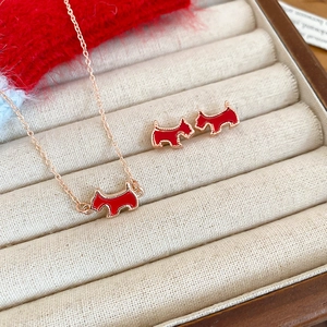 Detail of red enamel dog pendant and earrings in a rose gold jewelry gift box