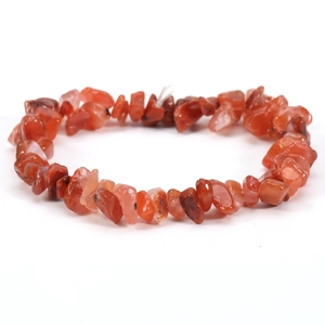 Close-up of polished irregular red agate gravel beads on a stretch elastic bracelet
