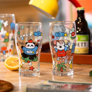 Set of two stylish glass beer mugs with fancy cartoon patterns in a cozy home setting