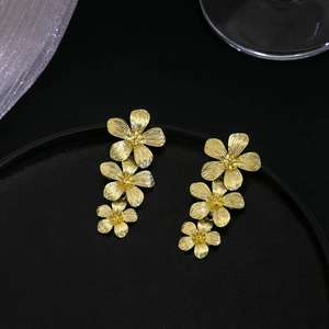 Elegant gold flower drop earrings with three-layer metal floral petals on black stand