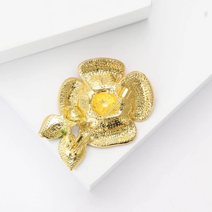 Macro shot of the gold alloy poppy brooch back showing the standard safety pin clasp