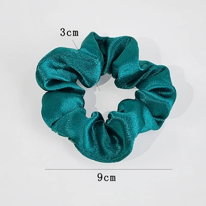 Detail view of a 9cm dark teal satin scrunchie showing 3cm band width and smooth texture