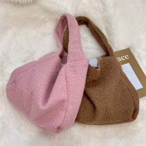 Close-up of soft curly plush tote bags in pink and brown, showcasing fleece texture