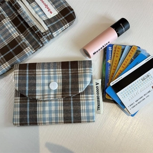 Detail view of checkered fabric card holder with zipper pocket and snap button closure