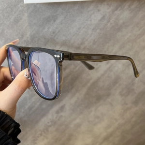Detail of grey transparent oversized glasses frame with silver arrow accent on temple
