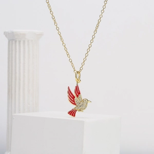 Elegant gold plated love bird pendant necklace with red enamel and shimmering cubic zirconia