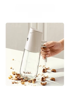 Detail of durable lead-free glass oil sprayer showing impact resistance with walnuts