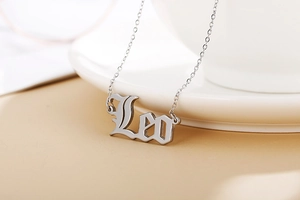 Close-up of silver Gothic Leo pendant necklace on a minimalist aesthetic background