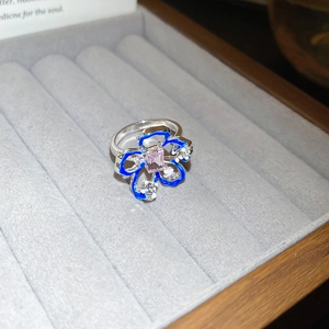 Vista dettagliata dell'anello a fiore in argento con smalto blu e gemma rosa in astuccio