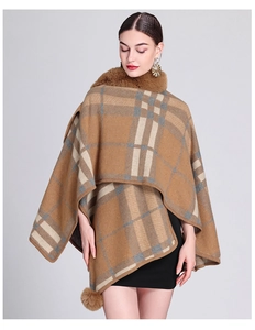 Detail view of the brown plaid knit poncho with plush faux fur collar and pom-pom charm