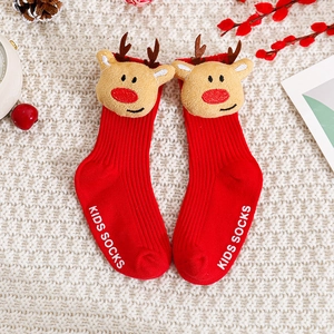 Gros plan sur chaussettes de Noël rouges pour bébé avec renne 3D et texture tricotée