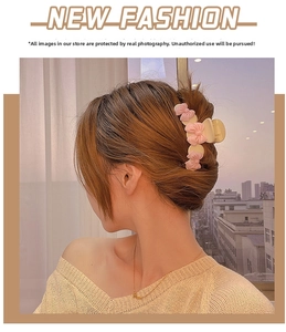Detail of a large pink bow hair claw clip styled on a woman's hair in natural light