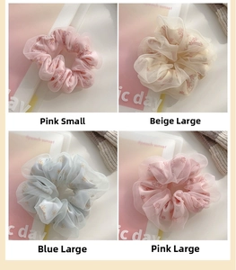 Detail showing sheer daisy patterned hair scrunchies in pink, beige and blue colors