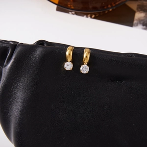 Detail of 18K gold stainless steel hoop earrings with round zircon on leather texture