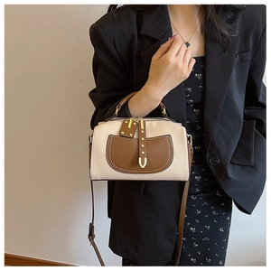 Détail du petit sac carré bicolore avec clous dorés et texture en similicuir lisse