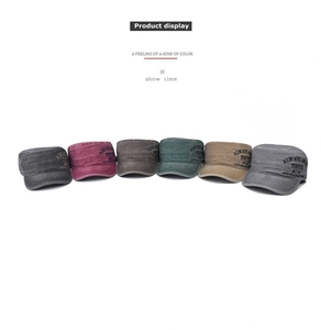 Detail of multi-color washed cotton cadet caps with side youth embroidery and vintage texture