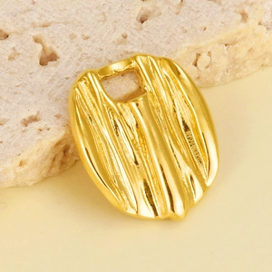 Macro view of golden stainless steel oval pendant with irregular vertical stripes texture