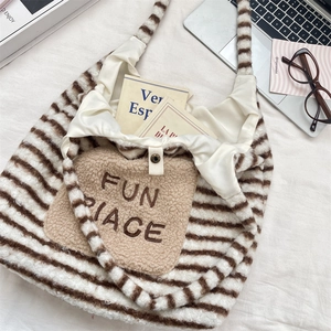 Détail du sac fourre-tout rayé en peluche avec broderie et fermeture à pression
