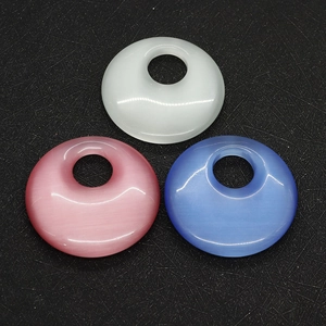 Detailed view of polished 40mm round cat eye stone pendants in white pink and blue