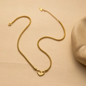 Gold stainless steel heart necklace with I am worthy engraving on minimalist stone background