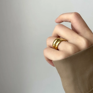 Detail of minimalist double-layered gold ring on finger with elegant metallic texture